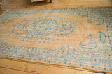 Distressed Oushak rug, pale tangerine field, soft blue and mint green paisley corner.