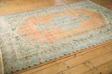 Distressed vintage Oushak rug border showing mostly even wear, exposed foundation, and pale orange, mint, ivory tones.