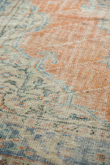 Worn texture of a distressed Oushak rug in apricot, faded blue, and ivory.