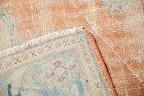 Distressed vintage Oushak rug with apricot pile, visible foundation, and fringed corner.
