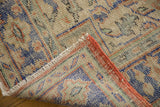 Distressed vintage Oushak pile showing visible foundation, red side binding, and pale blue motifs.