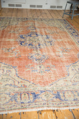 Distressed vintage Oushak carpet, low pile texture with visible foundation and muted floral sprays.
