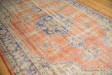 Overall distressed texture of a vintage Oushak rug, showing pale red and blue floral sprays.