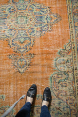 Distressed Oushak carpet with low pile, faded orange field, blue and green Rococo vinery.