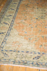 Textured pile of vintage distressed Oushak rug, low shorn, dusty apricot field, navy border.