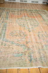 Low shorn pile of a distressed vintage Oushak, pale blush and mint aqua green.