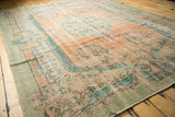 Vintage distressed Oushak rug corner with low pile, visible foundation, and mint green border.