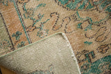 Close-up of distressed Oushak carpet pile, secured side, and hand-knotted foundation.