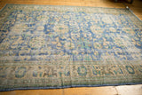 Distressed vintage Oushak carpet with low shorn pile and a floral border pattern.