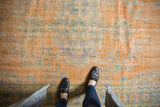 Worn tangerine, mint, and blue floral design on a distressed vintage Oushak rug.