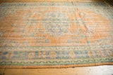 Distressed Oushak carpet with low shorn pile, dusty tangerine orange, and pale blue motifs.