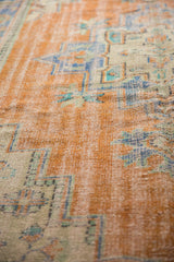 Distressed Oushak rug pile showing low shorn apricot, antique ivory, and sky blue geometric design.