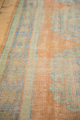 Distressed Oushak rug texture reveals faded tangerine, mint, blue, and mostly even wear.
