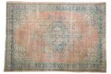 Distressed blush rose Oushak rug with a faded navy and mint floral medallion.