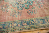 Distressed vintage Oushak border with faded navy, blush, and mint patterns.