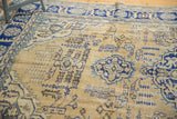 Detail of distressed Oushak rug: worn ivory field, visible knot heads, navy blue patterns.