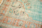 Distressed vintage Oushak rug showing abrashed aqua blue field and terracotta Rococo border.