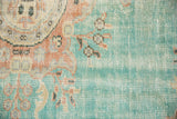 Distressed pile texture with abrashed aqua blue field and terracotta Rococo stylization.