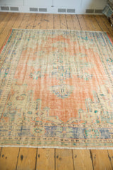 Distressed vintage Oushak rug fringe and worn bottom edge showing faded peach and blue.