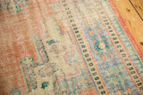 Distressed Oushak rug's worn texture, showing faded peach, ivory, and sky blue tones.