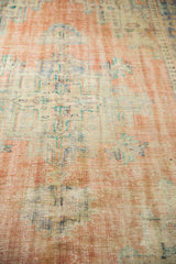 Faded peach and ivory distressed texture of a vintage Oushak rug's low pile.