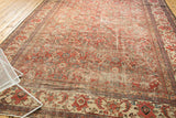 Corner view of a vintage Mahal carpet with worn Herati motifs and contrasting ivory border.