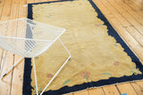 Vintage Peking rug detail of dark curvilinear border with blush mauve and mint green floral motifs.