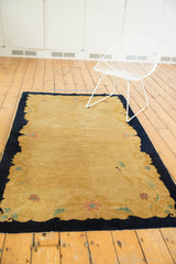 Rococo-inspired black curvilinear border and blush, mint floral motifs on a vintage Peking rug.