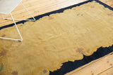 Curving dark navy border and pale beige gold field with Rococo-inspired floral motifs.