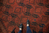 Geometric navy blue medallions on rich cochineal red field of a vintage Ersari rug.