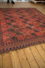 Vintage Ersari rug's dark goat hair fringe and cochineal red geometric border.