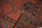 Vintage Ersari rug with cochineal red field, navy geometric patterns, brown goat hair selvage, and tattered fringe.