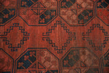 Vintage Ersari rug showing geometric relief, stepped patterns in cochineal red, navy blue.