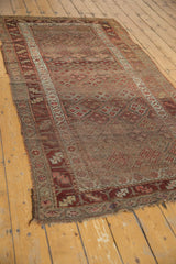Tattered end of an Antique Kurdish runner, highlighting its main geometric border and worn, checkered field.