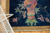 Colorful Art Deco ornate vase and vine design on a dark blue runner.