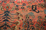 Vintage American Sarouk rug detail: navy floral patterns on a dusty red field with low pile.