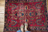 Worn cherry red Lilihan rug with shadow medallion of palmettes and blossoming trees.