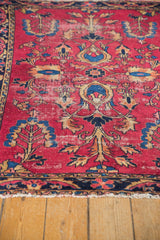 Detail of vintage Lilihan rug: cherry red field, navy palmettes, blossomed trees, and visible foundation.