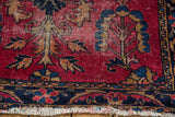 Lilihan rug with cherry red low pile, gold blossomed trees, navy border, tattered fringe.
