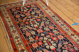 Detail of vintage Malayer runner showing allover Henna plant design, tattered side, and light end loss.