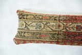 Hand-knotted pattern detail of antique rug fragment pillow in beige, red, and blue.