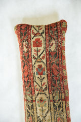 Hand-knotted antique rug fragment pillow showcasing intricate red, cream, and blue floral details.