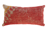 Antique Turkish rug fragment pillow in distressed red, muted beige, and yellow abstract design.