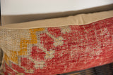 Textured antique Turkish rug fragment pillow, distressed red, cream, yellow patterns, beige backing.
