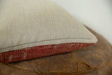Pillow's side showing textured beige backing and rich red antique Turkish rug fragment.