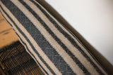Textured onyx black and natural striped pattern of a one-of-a-kind lumbar pillow.