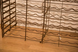 Aged patina and wavy bottle supports on the antique French iron wine rack.