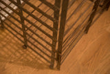 Textured rust patina on the antique French iron wine rack's interlocking bars.