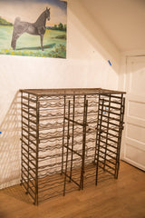 Bottom right corner of the antique French iron wine rack, showing aged patina and feet.