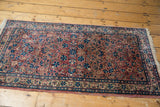 Scrolling red, ivory, and blue floral vinery on the Persian Kerman runner.